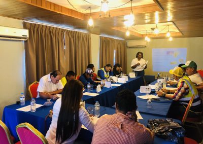 A group of people sitting around tables in front of papers.