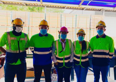 A group of people wearing safety vests and hard hats.
